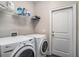 Bright laundry room featuring white washer and dryer, storage shelves, and a convenient access door at 630 Heartwood Dr., Conway, SC 29526