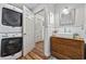 Compact bathroom/laundry room features stacked washer and dryer, modern sink, and wood-look flooring at 645 Boundary Line Dr. Nw, Calabash, NC 28467