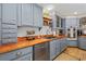 A well-appointed kitchen showcases blue cabinetry, wood countertops, and stainless steel appliances for a modern feel at 645 Boundary Line Dr. Nw, Calabash, NC 28467