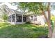Exterior view of the backyard with a screened porch, and lush lawn at 672 Ashley Manor Dr., Longs, SC 29568