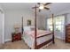 Cozy bedroom with a four-poster bed, ceiling fan, and natural light from a large window at 672 Ashley Manor Dr., Longs, SC 29568