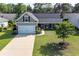 Charming single-Gathering home with a well-manicured lawn, attached garage, and inviting front porch at 672 Ashley Manor Dr., Longs, SC 29568