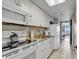 This well-lit kitchen includes white cabinets, a full-size refrigerator, and modern appliances at 6900 N Ocean Blvd. # 1437, Myrtle Beach, SC 29572