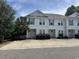 Charming townhome with white siding, double-hung windows, and inviting curb appeal surrounded by lush greenery at 730 Madiera Dr. # 101, North Myrtle Beach, SC 29582