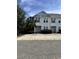 Charming townhome with white siding, double-hung windows, and inviting curb appeal surrounded by lush greenery at 730 Madiera Dr. # 101, North Myrtle Beach, SC 29582
