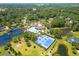 Aerial view featuring a community swimming pool, tennis courts, lake, and neighborhood at 79 Windsor Circle Sw, Ocean Isle Beach, NC 28469