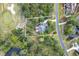 Aerial view of the property outlining the home, surrounding trees, road, and pond at 79 Windsor Circle Sw, Ocean Isle Beach, NC 28469