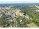 Aerial view of the property, surrounding neighborhood, golf course, trees and nearby highway at 79 Windsor Circle Sw, Ocean Isle Beach, NC 28469