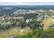 An aerial view of a home surrounded by trees near a golf course and water features at 79 Windsor Circle Sw, Ocean Isle Beach, NC 28469