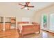 This bedroom features a ceiling fan, light hardwood floors, a bed, a sink, and exterior doors at 79 Windsor Circle Sw, Ocean Isle Beach, NC 28469