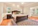 Spacious bedroom with a large bed, a ceiling fan, and natural light from two windows at 79 Windsor Circle Sw, Ocean Isle Beach, NC 28469