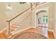 Grand foyer featuring hardwood floors, staircase, chandelier, and an open archway leading to the living space at 79 Windsor Circle Sw, Ocean Isle Beach, NC 28469