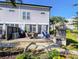 Outdoor deck with dining area, grill, and fireplace, set in a landscaped backyard with lush greenery at 80 Landing Dr. # 80, Pawleys Island, SC 29585