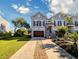 Charming two-story home features a brown garage door, stone details, and an inviting front porch at 80 Landing Dr. # 80, Pawleys Island, SC 29585
