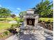 Exterior fireplace on the patio surrounded by garden, perfect for outdoor entertaining and relaxation at 80 Landing Dr. # 80, Pawleys Island, SC 29585