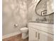 Clean and modern powder room with a white vanity, granite countertop, and a decorative oval mirror at 80 Landing Dr. # 80, Pawleys Island, SC 29585