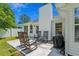 Inviting backyard with rocking chairs, lush lawn, and a covered grill, perfect for outdoor entertaining at 9607 Kings Grant Dr., Murrells Inlet, SC 29576