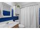 Stylish bathroom with a shower, framed mirror, vanity, and blue and white patterned wallpaper at 9607 Kings Grant Dr., Murrells Inlet, SC 29576