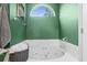 Bright bathroom featuring a soaking tub, green walls, and arched window providing natural light at 9607 Kings Grant Dr., Murrells Inlet, SC 29576