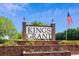Welcoming Kings Grant community sign with brick base, landscaping, and American flag at 9607 Kings Grant Dr., Murrells Inlet, SC 29576
