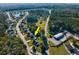 Aerial view of a home, surrounded by lush greenery and neighborhood amenities, marked by a yellow arrow at 100 Woodlyn Ave., Little River, SC 29566