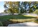 Large backyard featuring a well-maintained lawn, privacy fence, mature shade trees, and a stone patio at 100 Woodlyn Ave., Little River, SC 29566