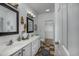 Bathroom with double sinks, white cabinetry, modern fixtures, and a closet at 100 Woodlyn Ave., Little River, SC 29566