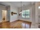 Bright dining area with hardwood floors and decorative lighting, adjacent to a bathroom and exterior door at 100 Woodlyn Ave., Little River, SC 29566