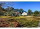 Beautifully landscaped home with a stone facade, lush green lawn, and a long driveway at 100 Woodlyn Ave., Little River, SC 29566