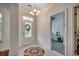 Welcoming foyer with tiled floor, decorative chandelier, and front door with glass window at 100 Woodlyn Ave., Little River, SC 29566