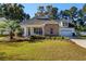 Charming home featuring stone accents, a well-manicured lawn, and an inviting front porch at 100 Woodlyn Ave., Little River, SC 29566