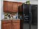 Kitchen featuring wood cabinetry, granite counters, and modern black refrigerator at 100 Woodlyn Ave., Little River, SC 29566