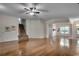 Open-concept living room featuring hardwood floors, a staircase, and abundant natural light at 100 Woodlyn Ave., Little River, SC 29566