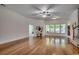 Spacious living room with hardwood floors, large windows, ceiling fan, and decorative console table at 100 Woodlyn Ave., Little River, SC 29566