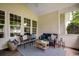 Inviting covered patio with wicker furniture, decorative pillows, and a cozy rug at 100 Woodlyn Ave., Little River, SC 29566