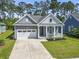 Charming single-story home featuring a welcoming front porch, attached garage, and a well-manicured lawn at 1007 Longwood Bluffs Circle, Murrells Inlet, SC 29576