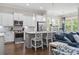 Modern kitchen with white cabinets, stainless steel appliances, a gray island with seating, and open to the living area at 1007 Longwood Bluffs Circle, Murrells Inlet, SC 29576
