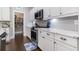 Elegant kitchen showcasing stainless steel appliances, granite countertops, white cabinets, and a view into the walk-in pantry at 1007 Longwood Bluffs Circle, Murrells Inlet, SC 29576