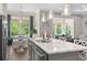 View of kitchen island and breakfast nook with natural light, leading to a living room with blue sofa at 1007 Longwood Bluffs Circle, Murrells Inlet, SC 29576