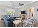 Cozy living room showcasing a comfortable blue sofa, stylish armchairs, a TV, and a sunroom in the background at 1007 Longwood Bluffs Circle, Murrells Inlet, SC 29576