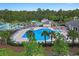 Aerial view of the community pool area with palm trees, a splash pad, and lounge chairs at 101 Culpepper Way # 1007, Myrtle Beach, SC 29579