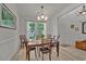 Well-lit dining room features wood flooring, a chandelier, and views of the front yard at 101 Culpepper Way # 1007, Myrtle Beach, SC 29579