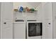 Bright laundry room with white washer and dryer, storage shelves, and white walls at 101 Culpepper Way # 1007, Myrtle Beach, SC 29579