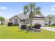 Beautiful single-story home with lush green lawn, charming landscaping, and a lovely palm tree at 10106 Duval Dr., Murrells Inlet, SC 29576