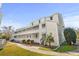 Exterior view of a three-story building with a well-maintained lawn, shrubs and walkways at 1100 Possum Trot Rd. # B202, North Myrtle Beach, SC 29582