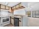Well-lit kitchen featuring appliances, a sink, and a bar top to a living space at 1100 Possum Trot Rd. # B202, North Myrtle Beach, SC 29582