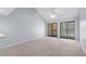 Bright living room with two sliding glass doors and neutral carpet, offering plenty of natural light at 1100 Possum Trot Rd. # B202, North Myrtle Beach, SC 29582