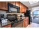 Efficient kitchen featuring wooden cabinets and modern black appliances at 1105 S Ocean Blvd. # 420, Myrtle Beach, SC 29577