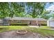 Spacious backyard features mature trees, brick home, trampoline, and a brick fire pit at 1108 Chicora Blvd., Conway, SC 29526