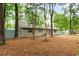 Exterior of a quaint single-story home showcasing brick facade, blue shutters, and mature trees at 1111 King St., Myrtle Beach, SC 29577